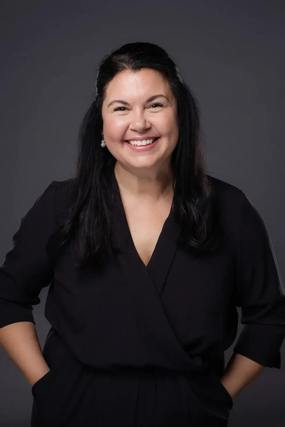 a woman keeping her hands in the pockets and posing for a picture with smile